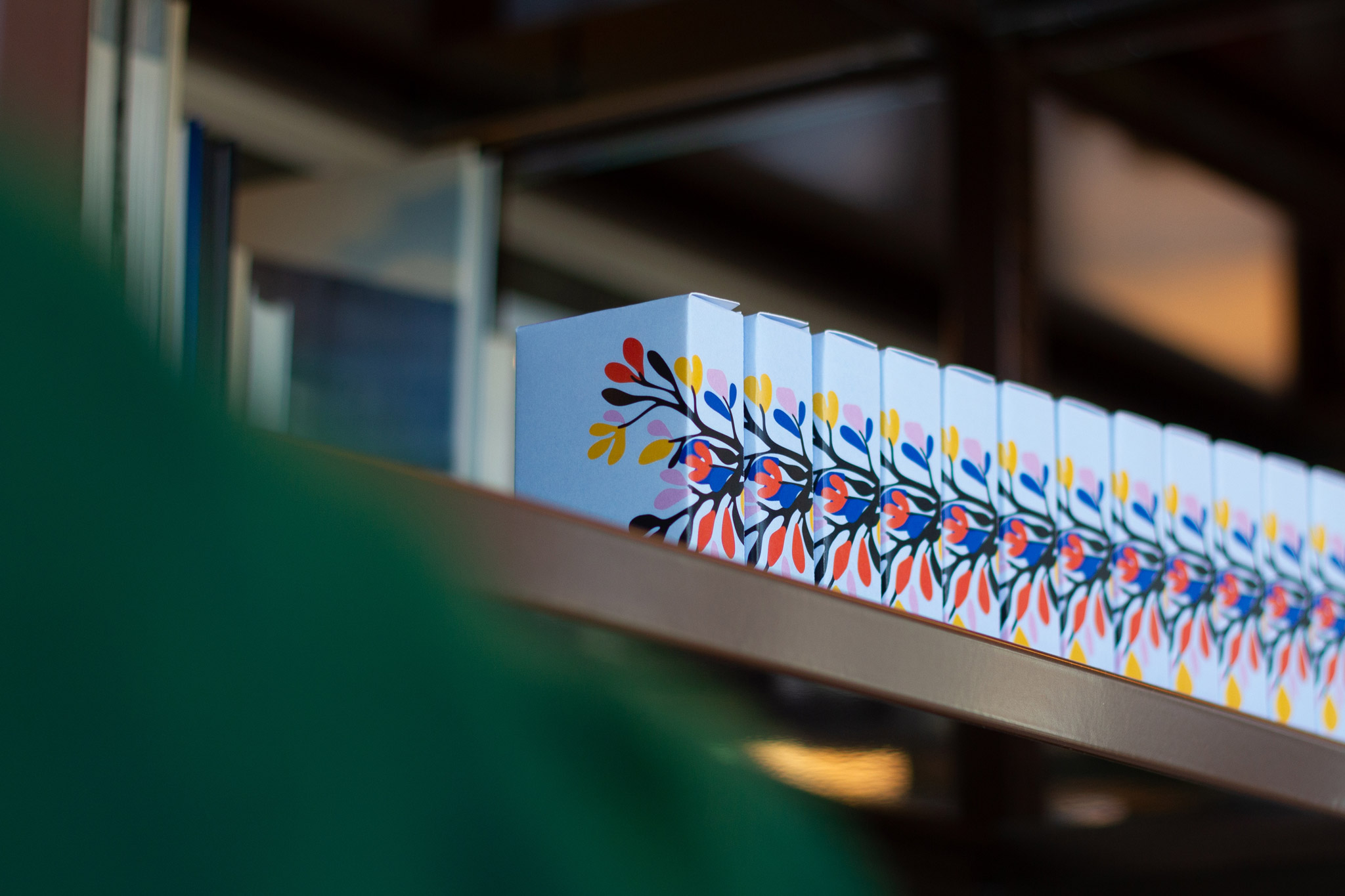 A row of Blossom card games on a shelf