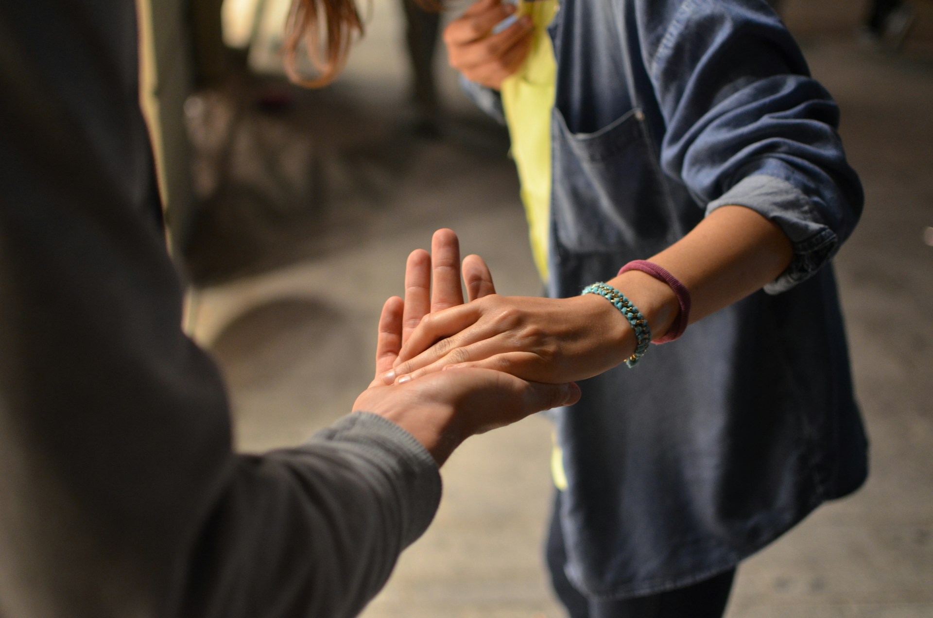 two people touching their hands on street